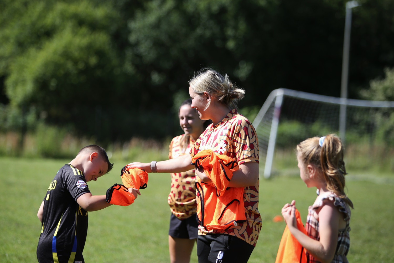 gwalia captain teaching kids football in a field