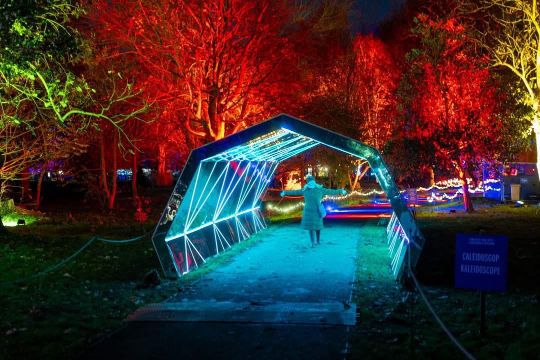 woman standing in illuminated tunnel at Christmas at Bute Park