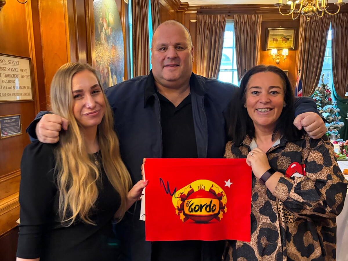 Francesca, Big Jon, Laura Pearson holding an El Gordo lottery flag