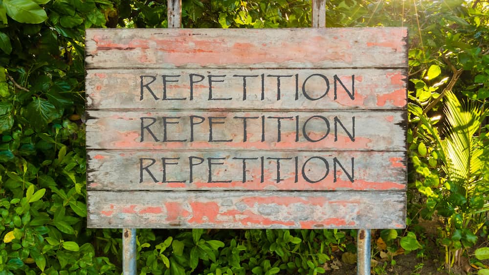 a sign with foliage behind it